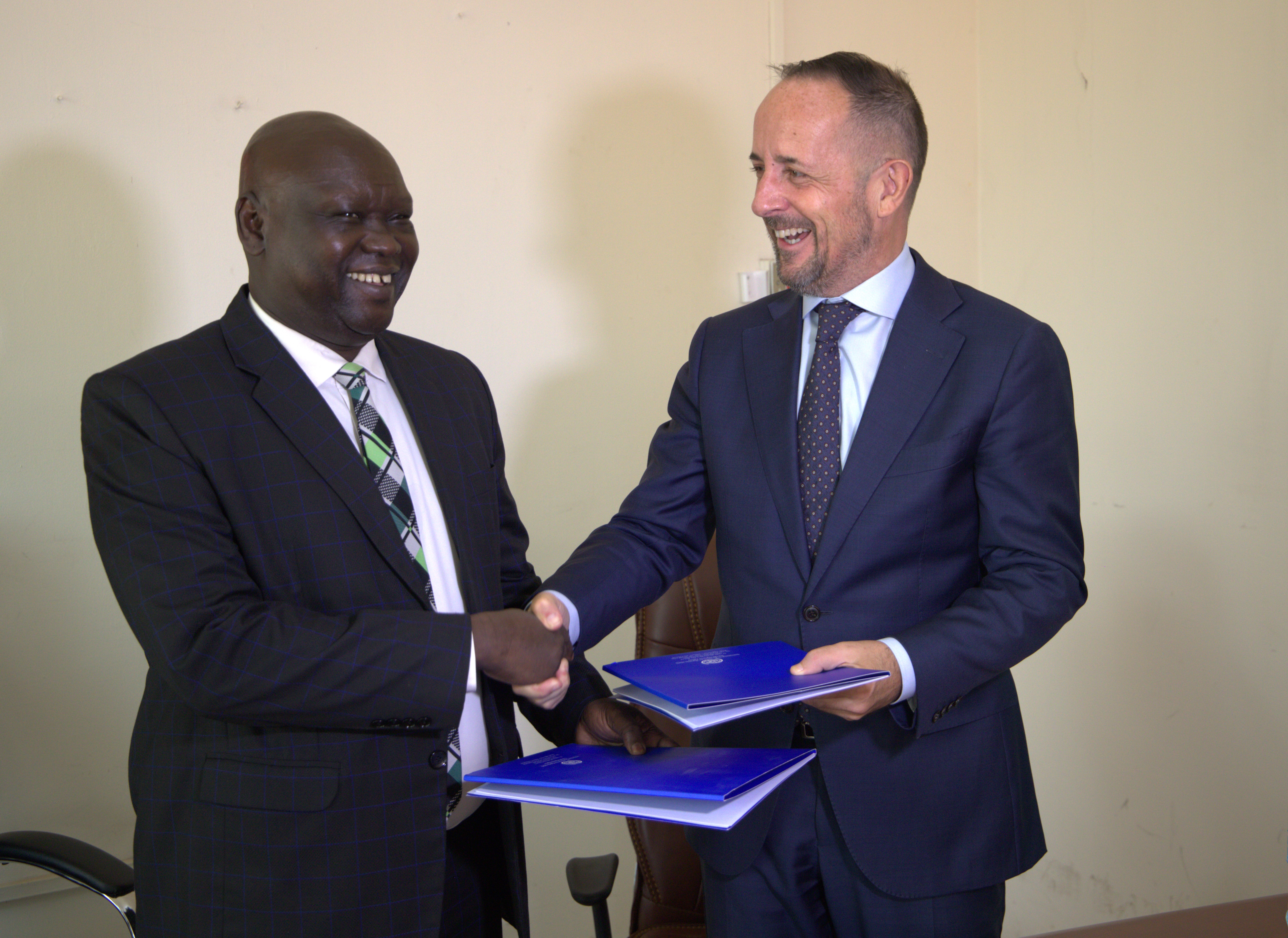 IOM’s Chief of Mission, Mr. Peter Van der Auweraert exchanges the signed MoU with Hon. Stephen Par Kuol, the Minister of Peacebuilding.