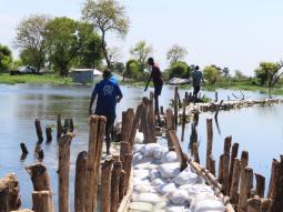 With support from IOM, local youth in Bor build dikes to prevent their villages from flooding.